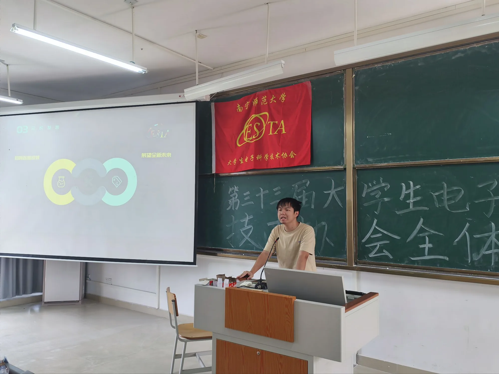 全体大会现场，发言者站在教室讲台前